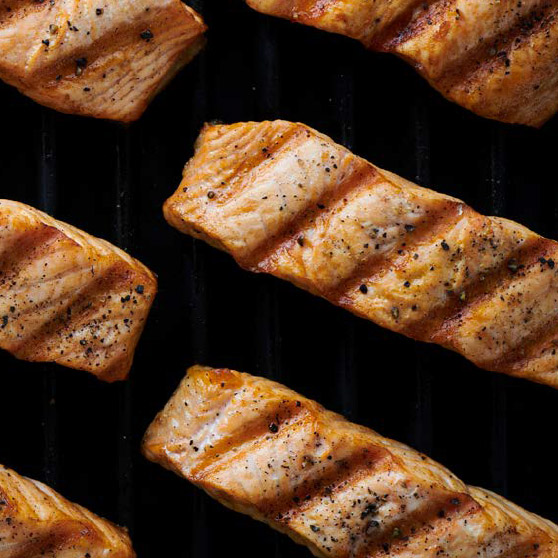 Filetti di salmone grigliati con evidenti segni della griglia e spezie – cotti alla perfezione con il CHEF'S COMBI di HOBART per risultati uniformi e professionali.