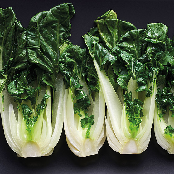 Quattro cespi di bok choy fresco con gambi bianchi e foglie verdi – cotti delicatamente con il CHEF'S COMBI di HOBART per mantenere freschezza e valori nutritivi.