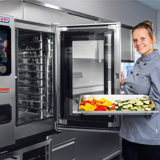 Una persona con giacca da chef tiene una teglia con verdure affettate come peperoni e zucchine davanti a un forno CHEF'S COMBI aperto con più ripiani e pannello di controllo digitale.