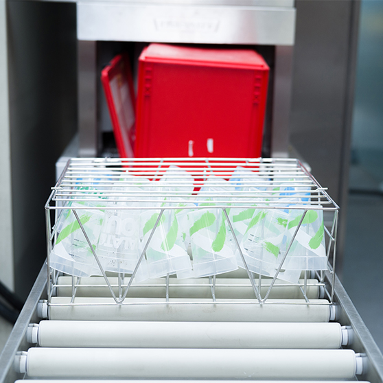 Cestello in acciaio inox con bicchieri riutilizzabili davanti all’impianto HOBART FUX, soluzione ad alte prestazioni per la pulizia dei bicchieri durante grandi eventi con costi ridotti.