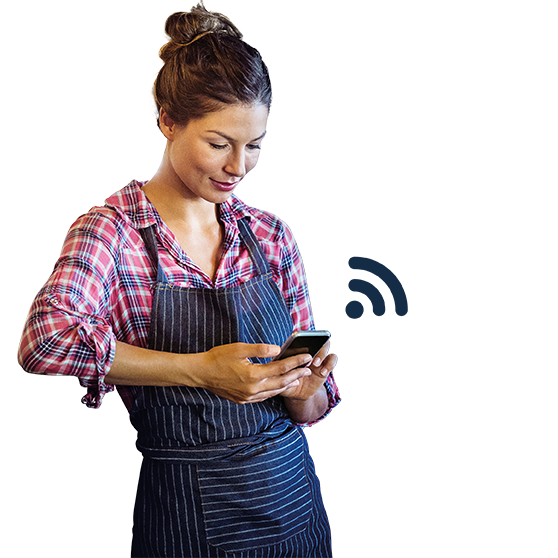 Persona in abbigliamento da lavoro che utilizza uno smartphone per controllare apparecchi di cucina tramite Smartconnect, con icona wireless, perfetto per connettività digitale e gestione efficiente nelle cucine professionali.