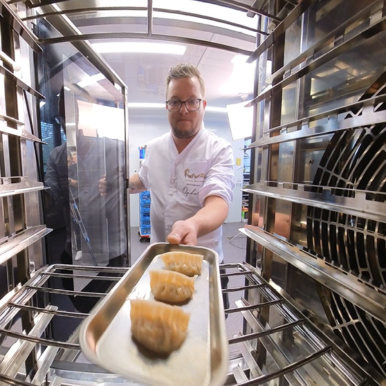 Una teglia con preparazioni viene inserita nella camera di cottura del HOBART CHEF’S COMBI, ripresa dall’interno per mostrare il processo di carico.